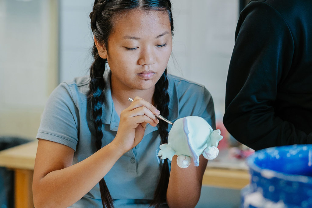 student painting pottery