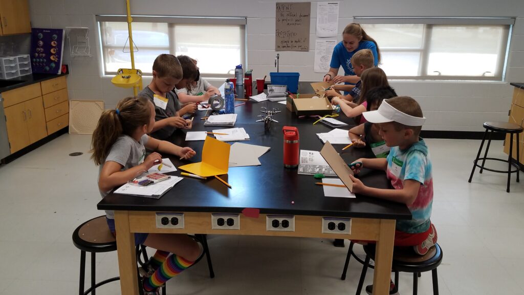 group of students doing an art project around a table