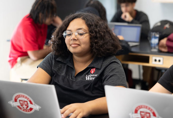 student at desk on laptop